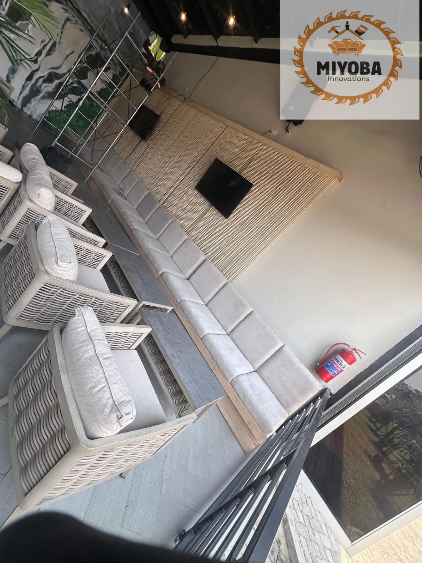 Restaurant lounge fit-out with grey tufted banquette seating and wood accent wall by Miyoba Innovations